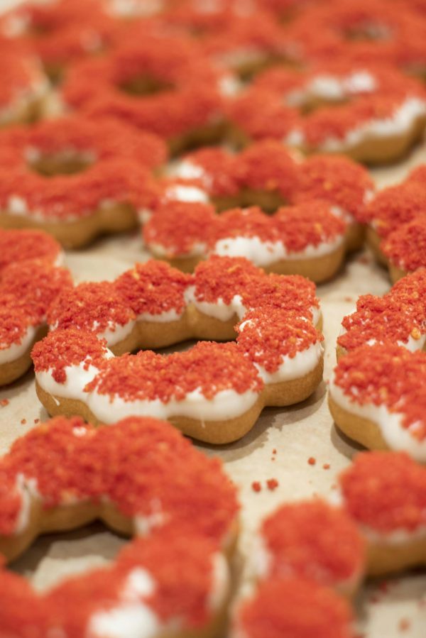 Close-up photo of mochi donuts topped with vibrant red sprinkles, showcasing intricate detail.